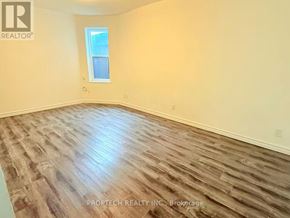 Toronto (North Riverdale) multi-family for rent - A room with wooden flooring and a window.