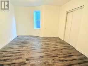 Toronto (North Riverdale) multi-family for rent - A room with wooden flooring and a window.