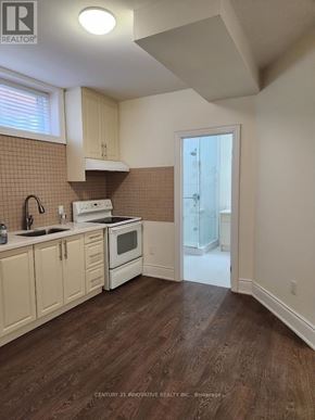 Toronto (Scarborough Village) apartment for rent - A kitchen with wooden floors and white appliances.