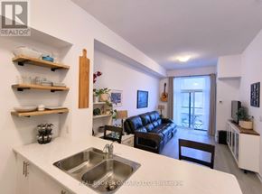 Hamilton (Waterdown) condo for rent - A kitchen with a sink and a couch in the background.