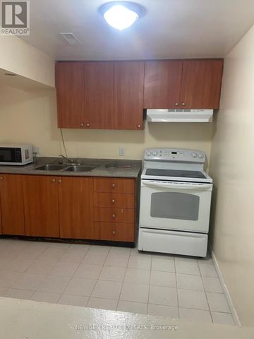 Mississauga (Hurontario) apartment for rent - A kitchen with a white oven and microwave.