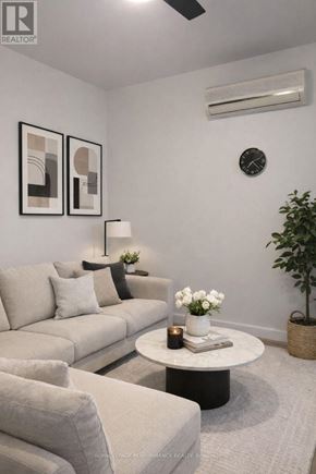 Casselman apartment for rent - A living room with a grey couch, a white coffee table, and a plant.