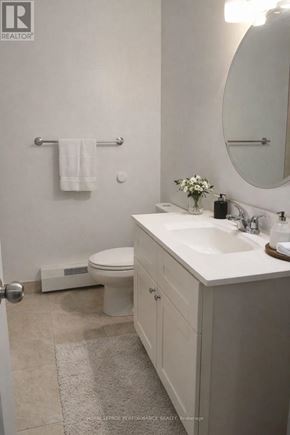 Casselman apartment for rent - A white bathroom with a toilet, sink, and mirror.