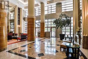 Toronto (Bay Street Corridor) condo for rent - A large lobby with a marble floor and a tree in the corner.