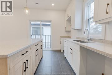Windsor duplex for rent - A kitchen with white cabinets and a marble countertop.