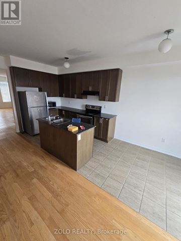 Brampton (Northwest Brampton) townhouse for rent - A kitchen with wooden floors and white walls.