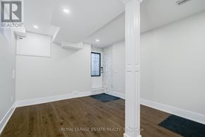 Toronto (Birchcliffe-Cliffside) apartment for rent - A spacious room with wooden floors and white walls.