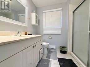 Windsor apartment for rent - A bathroom with a toilet, sink, and mirror.