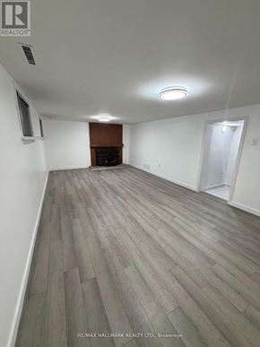 Toronto (Tam O'shanter-Sullivan) apartment for rent - A spacious room with a fireplace and wood flooring.