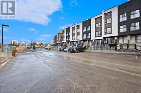 St. Catharines (E. Chester) townhouse for rent - A street view of a residential area with apartment buildings and cars parked on the side.
