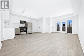 St. Catharines (E. Chester) townhouse for rent - A spacious room with wooden flooring and white walls, with a kitchenette in the corner.