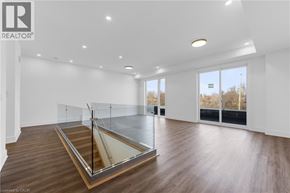 St. Catharines townhouse for rent - A spacious room with a glass partition wall and wooden flooring.