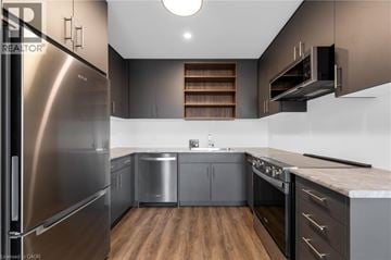 St. Catharines townhouse for rent - A modern kitchen with stainless steel appliances and wooden floors.