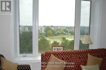 Markham (Middlefield) condo for rent - A living room with a couch and a window overlooking a landscape.