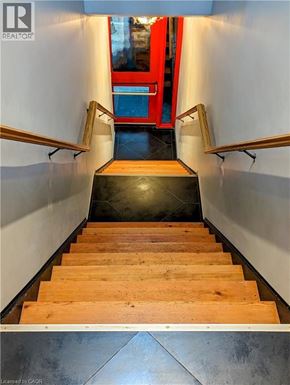 Hamilton apartment for rent - A set of wooden stairs with a metal handrail on the left and right side.