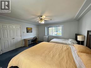 Burnaby apartment for rent - A bedroom with a large bed and a ceiling fan.