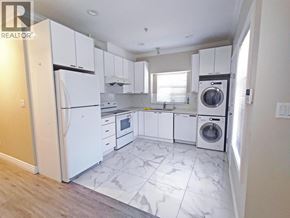 Vancouver apartment for rent - A white kitchen with a refrigerator, washing machine, and dishwasher.