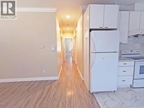 Vancouver apartment for rent - A kitchen with white appliances and wooden floors.