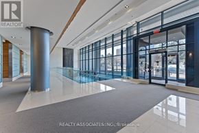 Toronto (Bayview Village) condo for rent - A modern hallway with a glass wall and a pillar.