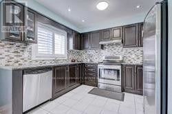 Toronto (Rouge) apartment for rent - A modern kitchen with dark wood cabinets and a white tiled floor.