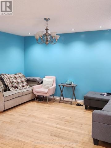 Toronto (Rouge) apartment for rent - A living room with a grey couch, a pink chair, and a small table with a blue object on it.
