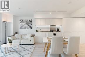 Vancouver apartment for rent - A modern living room with a white sofa, a coffee table, and a dining table set up.