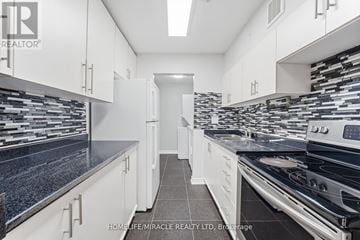 Toronto (West Hill) townhouse for rent - A kitchen with white cabinets and black countertops.