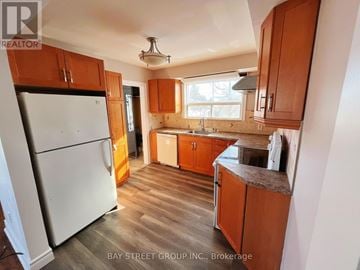 Richmond Hill (Crosby) apartment for rent - A kitchen with wooden cabinets and a white refrigerator.