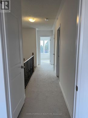 South-West Oxford townhouse for rent - A hallway with white walls and a carpeted floor.