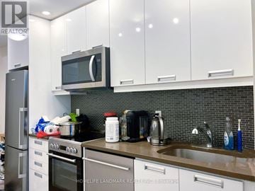 Toronto (Waterfront Communities) condo for rent - A kitchen with a stove, oven, microwave, and sink.