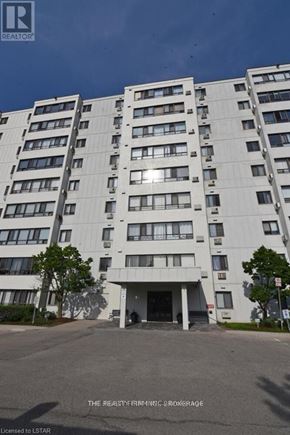 London South (South D) condo for rent - A tall white apartment building with a tree in front.