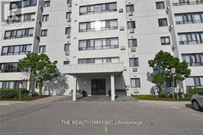 London South (South D) condo for rent - A tall white apartment building with a grey car parked in front.