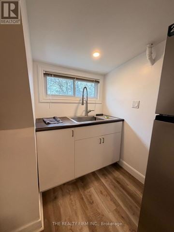 London East (East M) duplex for rent - A kitchen with white cabinets and a window.