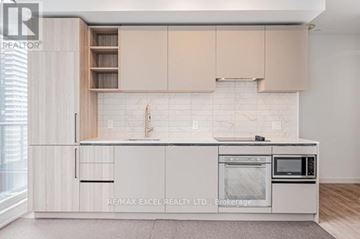 Toronto (Waterfront Communities) condo for rent - A kitchen with white cabinets and a white tiled backsplash.