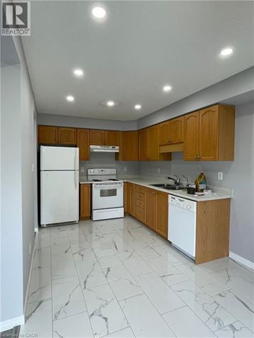 Kitchener apartment for rent - A kitchen with white appliances and wooden cabinets.