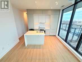Toronto (Don Valley Village) condo for rent - A modern kitchen with wooden floors and a large window overlooking a cityscape.