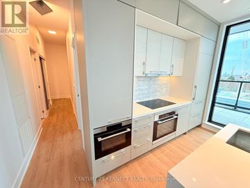 Toronto (Don Valley Village) condo for rent - A modern kitchen with white cabinets and a view of a construction site outside the window.