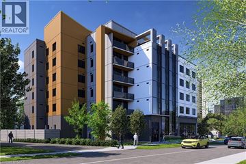 Waterloo condo for rent - A modern multi-story building with a yellow car parked in front.