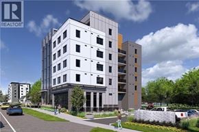 Waterloo condo for rent - A modern apartment building with a parking lot in front.
