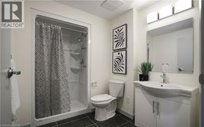 Waterloo condo for rent - A bathroom with a toilet, sink, and shower.