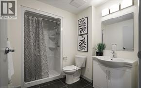 Waterloo condo for rent - A bathroom with a toilet, sink, and shower.