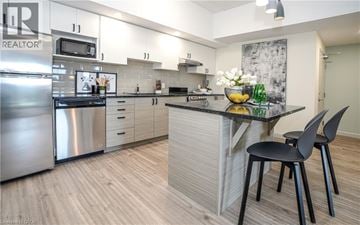 Waterloo condo for rent - A modern kitchen with a stainless steel refrigerator and a black chair.