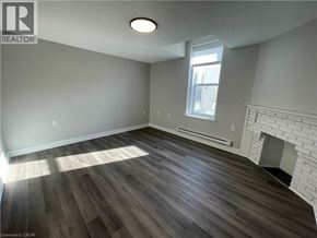 Welland apartment for rent - A room with a fireplace and wood flooring.