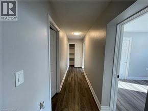 Welland apartment for rent - A long hallway with wood floors and white walls.