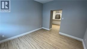 Welland apartment for rent - A room with wooden flooring and a grey wall.