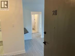 Hamilton condo for rent - A room with a door numbered 211 and a light switch.