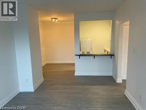 Hamilton condo for rent - A room with a white wall and a wooden floor.