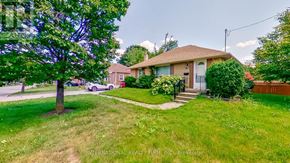 Toronto (Willowdale West) apartment for rent - A house with a brown roof and a white door is surrounded by a green lawn.