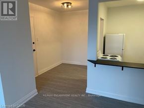 Hamilton (Ainslie Wood) condo for rent - A room with a white door and a white fridge.