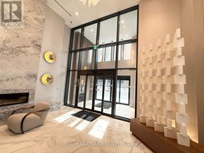 Hamilton (Corktown) condo for rent - A foyer with a fireplace and a wall of windows.